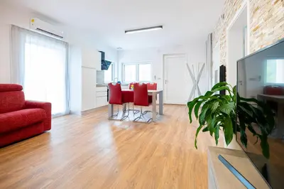 a living room with a table and red chairs at Hiša Kragelj in Most na Soči