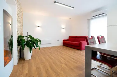 a living room with a red couch and a table at Hiša Kragelj in Most na Soči