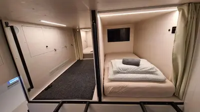 a small room with a bed and a mirror at Cabin HOSTEL in Ljubljana