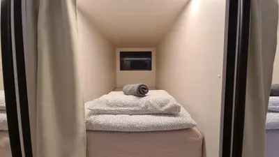 a small room with towels sitting on a stool at Cabin HOSTEL in Ljubljana