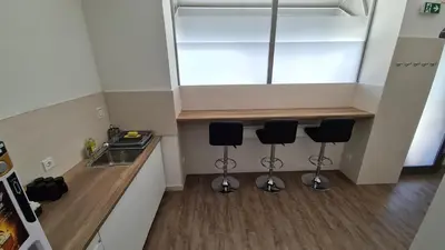 a kitchen with two bar stools and a sink at Cabin HOSTEL in Ljubljana