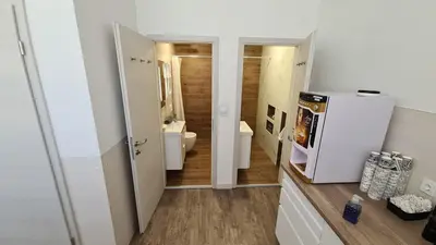 a bathroom with a white refrigerator and a toilet at Cabin HOSTEL in Ljubljana