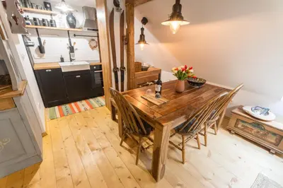 a dining room with a wooden table and chairs at Apartment DOMI in Soča