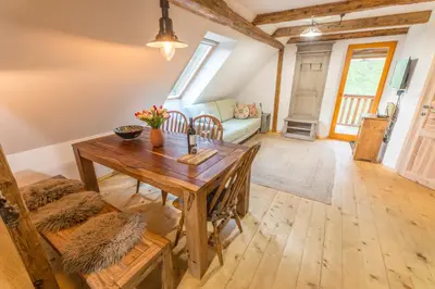 a living room with a wooden table and a couch at Apartment DOMI in Soča