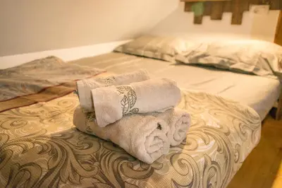 two folded towels sitting on top of a bed at Apartment DOMI in Soča