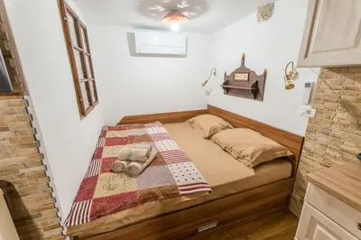a small bedroom with a bed with a quilt on it at Rustic Apartment PETRA in Soča