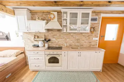 a kitchen with white cabinets and a sink at Rustic Apartment PETRA in Soča