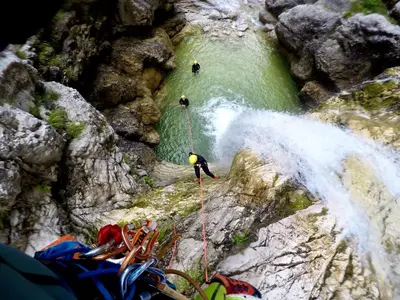 a group of people rappelling from a waterfall at Rustic Apartment PETRA in Soča
