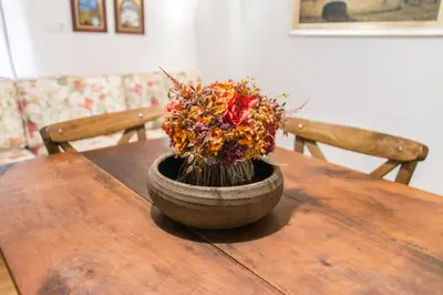 a wooden table with a vase with flowers on it at Rustic Apartment PETRA in Soča