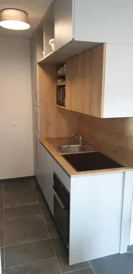 a kitchen with a sink and a microwave at Golte SkiCenter App MOUNTAIN VIEW WITH BALCONY in Mozirje