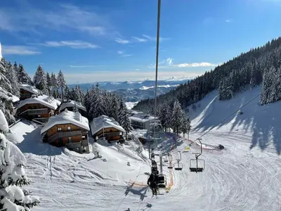 a ski resort with a ski lift in the snow at Golte SkiCenter App MOUNTAIN VIEW WITH BALCONY in Mozirje