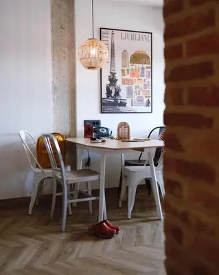 a dining room table with chairs and a lamp at ONE66 Hotel in Ljubljana