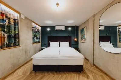 a bedroom with a large bed and a mirror at ONE66 Hotel in Ljubljana