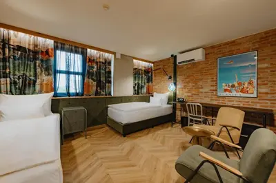 a bedroom with a bed and chairs in a room at ONE66 Hotel in Ljubljana