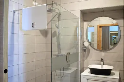 a bathroom with a sink and a glass shower at Cirus apartments in Kočevje