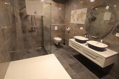 a bathroom with two sinks and a mirror and a toilet at Cirus apartments in Kočevje