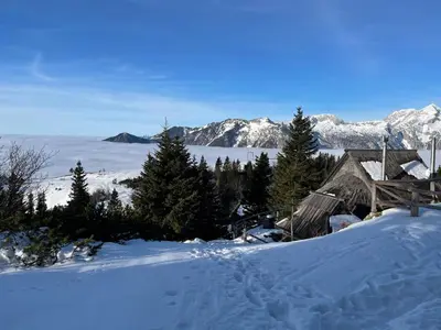 a cabin in the snow with mountains in the background at Alpine Chalet Velika Planina - Irenca - I Feel Alps in Stahovica