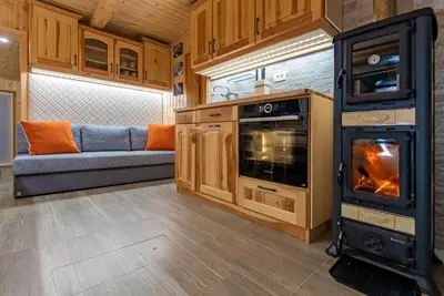 a living room with a stove and a couch at Alpine Chalet Velika Planina - Irenca - I Feel Alps in Stahovica