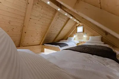 a room with two beds in a attic at Alpine Chalet Velika Planina - Irenca - I Feel Alps in Stahovica