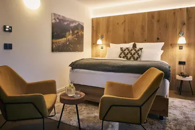 a hotel room with a bed and two chairs at Triangel Boutique Hotel in Kranjska Gora
