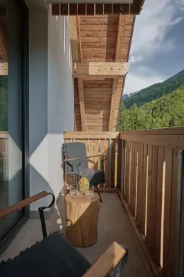 a balcony with a chair and a table on a deck at Triangel Boutique Hotel in Kranjska Gora