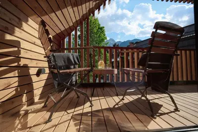 a chair and a table on a deck at Triangel Boutique Hotel in Kranjska Gora