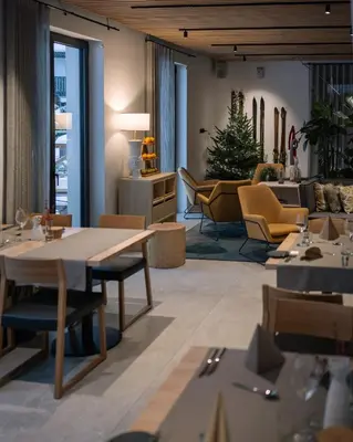 a restaurant with tables and chairs and a christmas tree at Triangel Boutique Hotel in Kranjska Gora