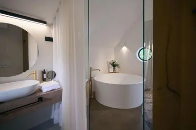 a bathroom with a tub and a sink and a mirror at Triangel Boutique Hotel in Kranjska Gora