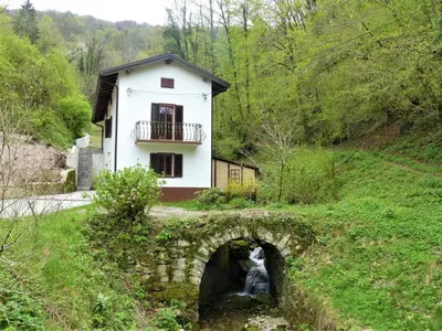 a house on a hill with a bridge at Hiša ob potoku in Avče