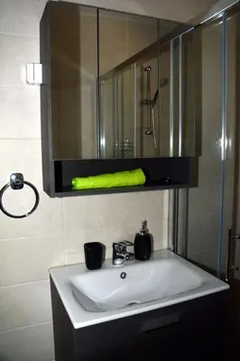 a bathroom sink with a mirror and a green towel at Hiša v Travniku in Šmartno