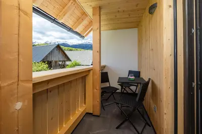 a small balcony with a table and chairs in a cabin at Pr `Agotnik Apartments & Rooms Bohinj in Bohinj