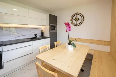 a kitchen with a wooden table with a flower in a vase at Pr `Agotnik Apartments & Rooms Bohinj in Bohinj