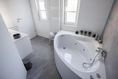 a bathroom with a large white tub in a room at Villa Xaxat in Koper