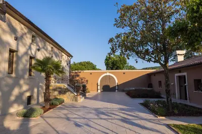 a driveway leading to a building with a tree at Villa Xaxat in Koper
