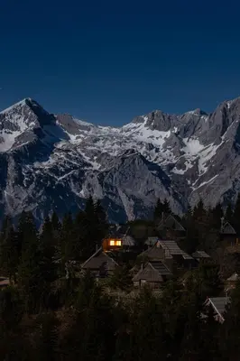 a mountain at night with a house in the foreground at Chalet Neza Velika Planina in Stahovica
