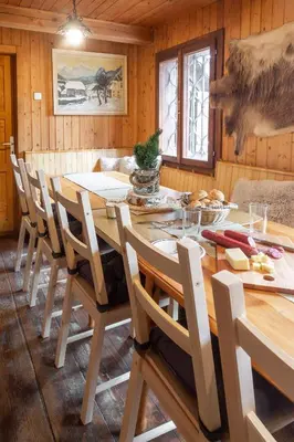 a dining room with a wooden table and chairs at Chalet Neza Velika Planina in Stahovica