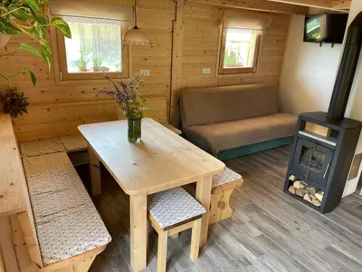 a living room with a table and a stove at Miha`s cottage in Bohinj