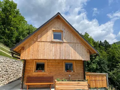 a log cabin with a bench in front of it at Miha`s cottage in Bohinj