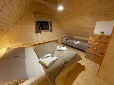 a room with a bed and a dresser in a cabin at Miha`s cottage in Bohinj