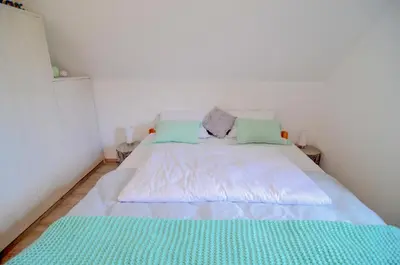 a bedroom with a large bed with two pillows at Flower house Podčetrtek in Podčetrtek