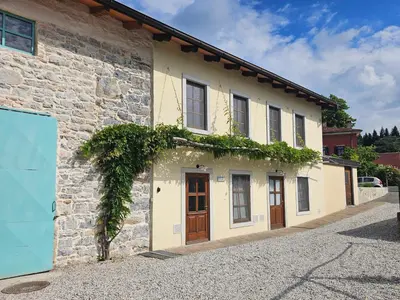 a stone building with doors and ivy on it at Apartma Kras in Komen