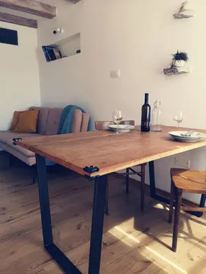 a wooden table in a living room with a couch at Apartma Kras in Komen