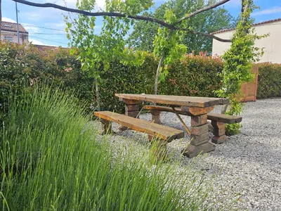 a picnic table and bench in a garden at Apartma Kras in Komen