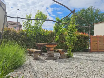a picnic table and bench in a garden at Apartma Kras in Komen