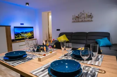 a living room with a table with plates and wine glasses at Zelena dolina in Cerkno