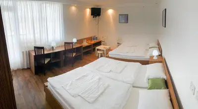 a bedroom with two beds and a dining room with a table at Restavracija in prenočišča ČARDA in Martjanci