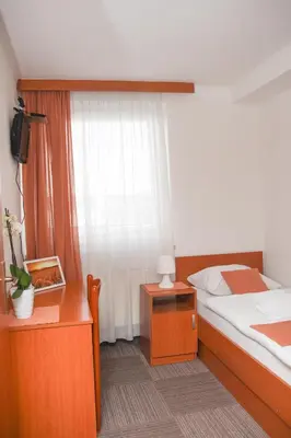 a bedroom with a bed and a dresser and a window at Restavracija in prenočišča ČARDA in Martjanci