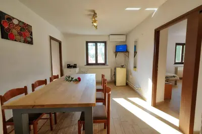 a dining room with a wooden table and chairs at Počitniška hiša Miklavčič Primorska in Divača