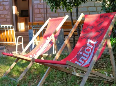 a couple of chairs sitting in the grass at Počitniška hiša Miklavčič Primorska in Divača