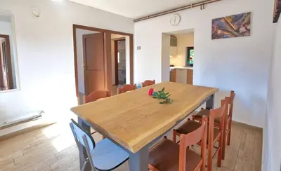 a dining room with a wooden table and chairs at Počitniška hiša Miklavčič Primorska in Divača